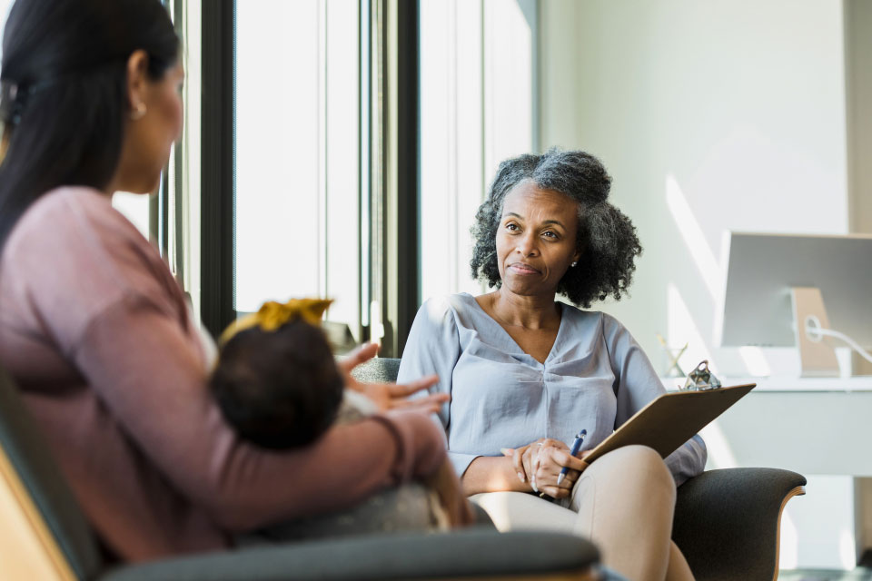 Lady talking to a mother and her chid