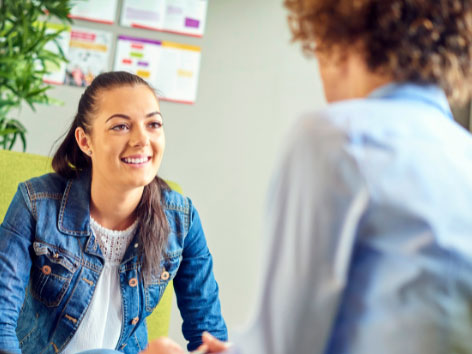 Happy young woman talking to an advisor